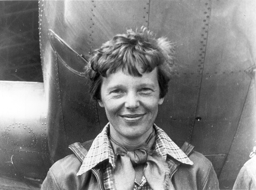 968px-Amelia_Earhart_standing_under_nose_of_her_Lockheed_Model_10-E_Electra,_small