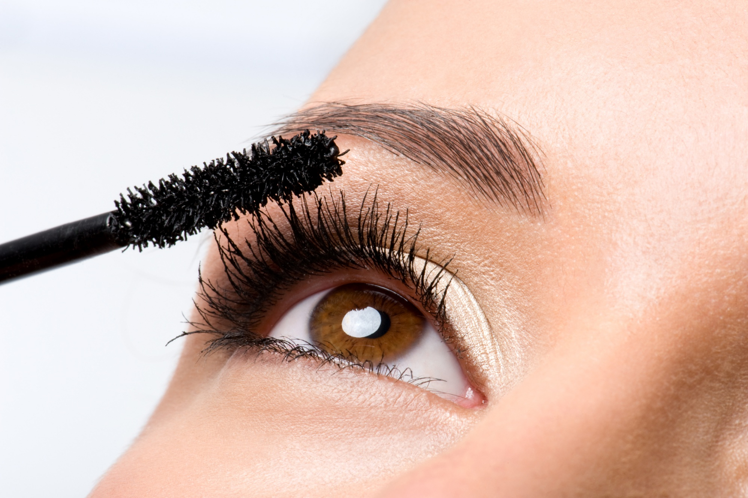 woman-applying-mascara-her-eyelashes-macro-shot