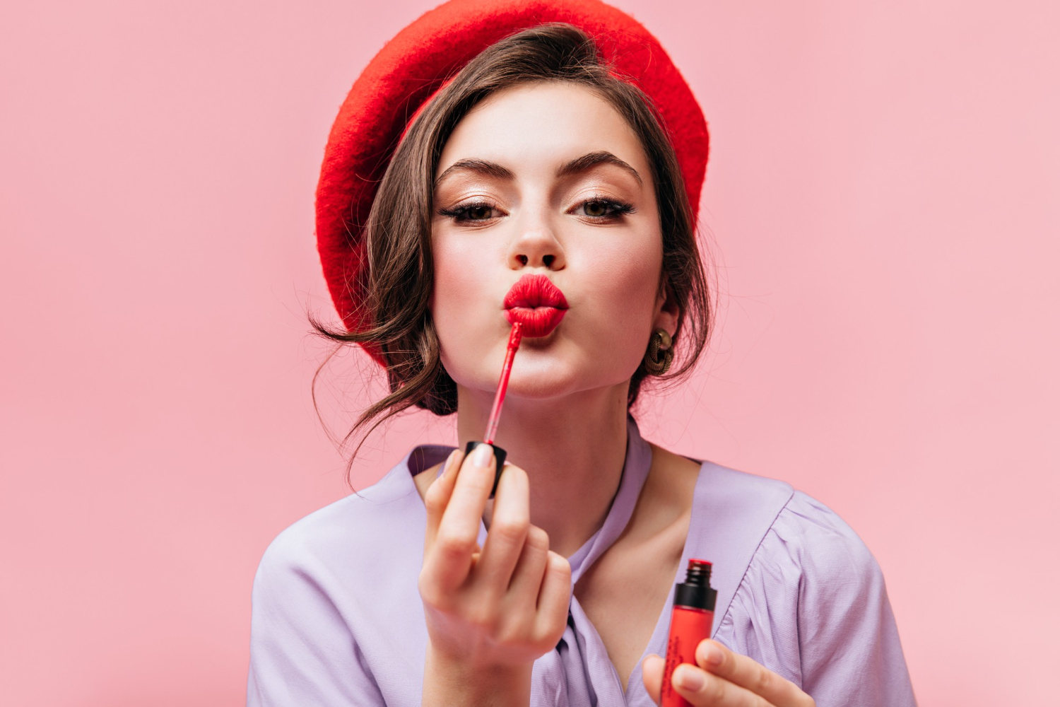 portrait-young-girl-red-beret-painting-her-lips-with-bright-lipstick-pink-background