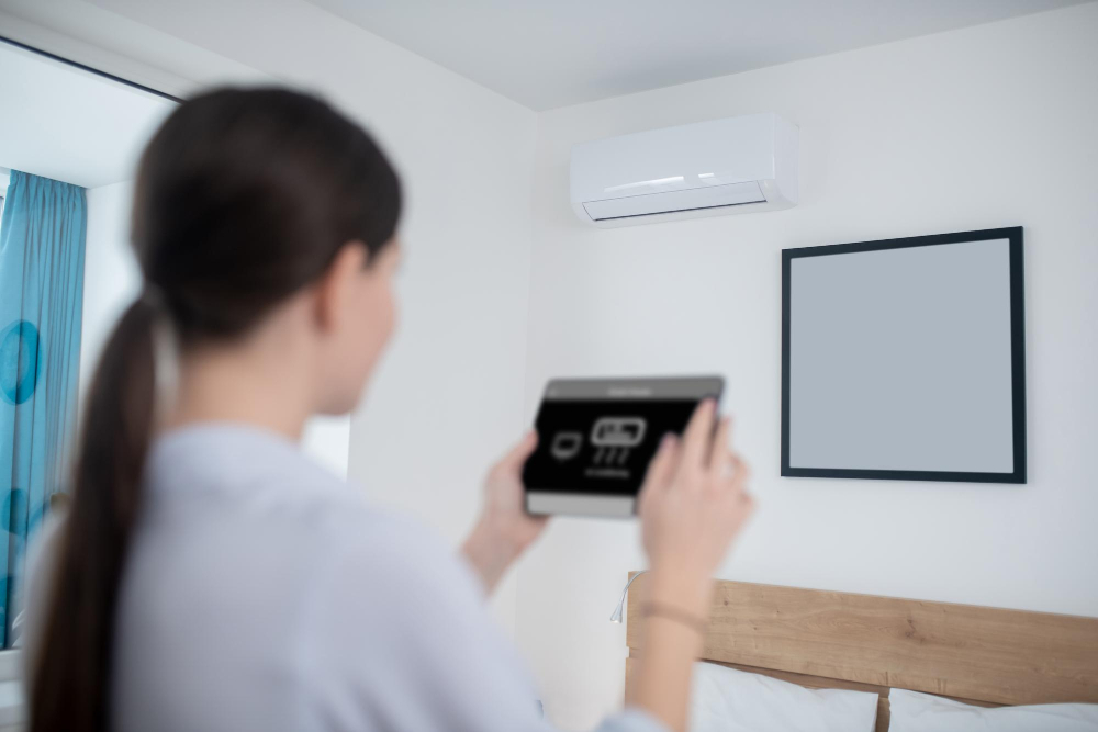 woman-turning-air-conditioner-using-tablet