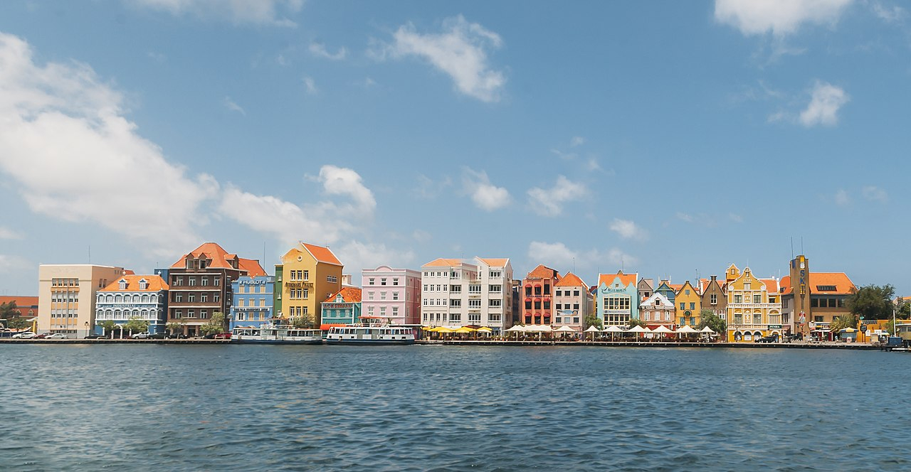 1280px-The_colorful_buildings_of_the_Handelskade_in_Willemstad,_Curaçao