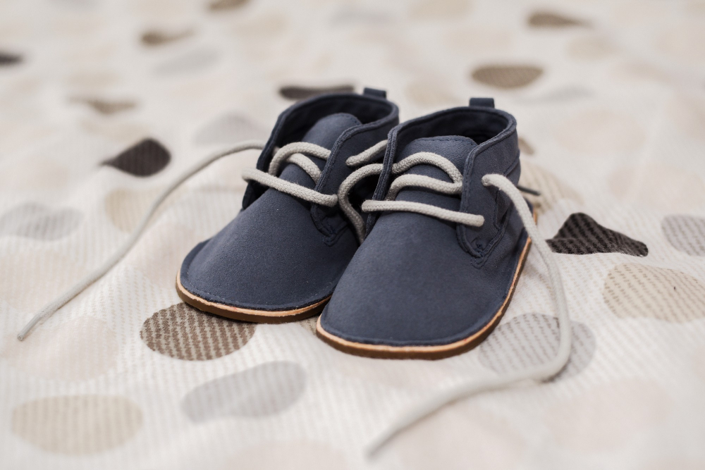 closeup-shot-baby-boy-shoes-bed